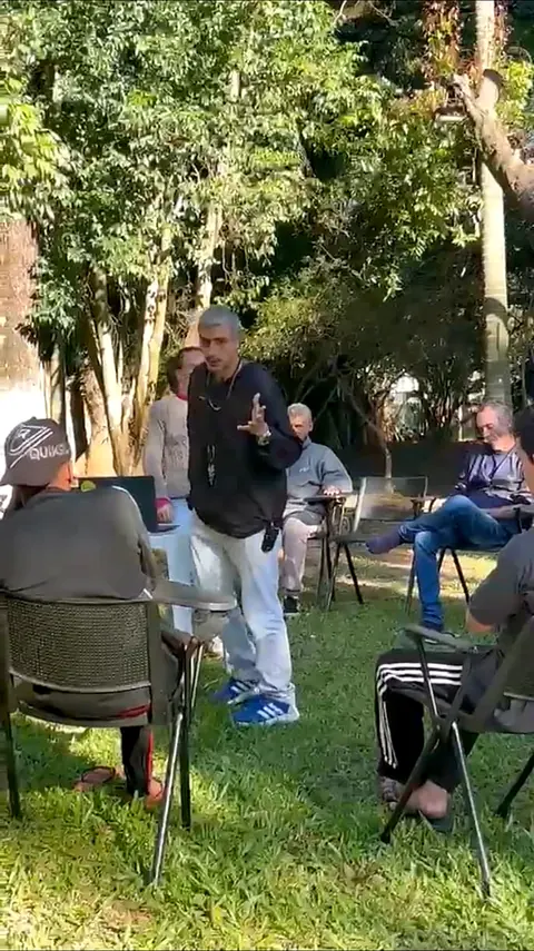 Roda de conversa ao ar livre, com o grupo sentado no jardim